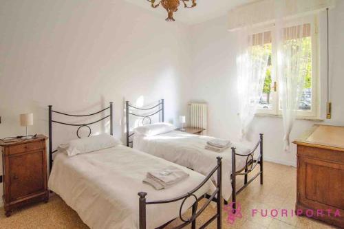 1 dormitorio con 2 camas, vestidor y ventana en Residence Dacci, en Parma