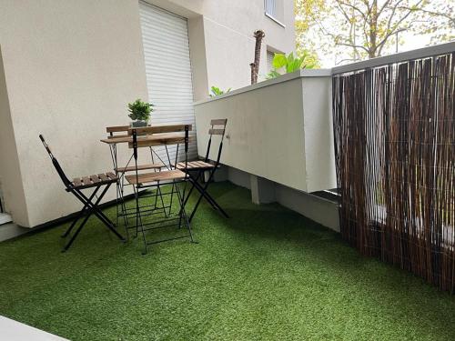 a patio with a table and chairs on a balcony at Bel appartement à 2 min des transports parisiens in Noisy-le-Grand