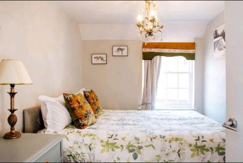a bedroom with a bed with a chandelier and a window at Whispering Place Georgian Grade II Sleeps 6 Adults 3 mins from Safari Park & Steam Train in Bewdley
