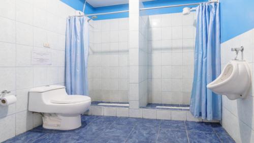y baño con aseo, urinario y lavamanos. en Beraja Family Hostel, en Lima