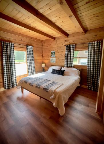 a bedroom with a bed in a wooden cabin at HGTV Log Cabin near Lake Willoughby, Burke, Jaypeak ang Kingdom Trails in Barton