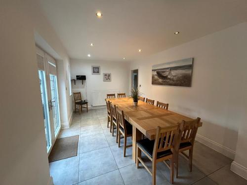 a dining room with a wooden table and chairs at Castlebar in Great Singleton