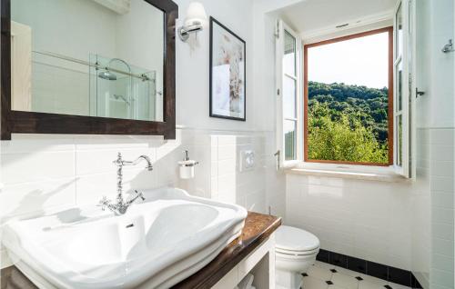 ein weißes Bad mit einem Waschbecken und einem Fenster in der Unterkunft Nice Home In Gruda With Outdoor Swimming Pool in Gruda