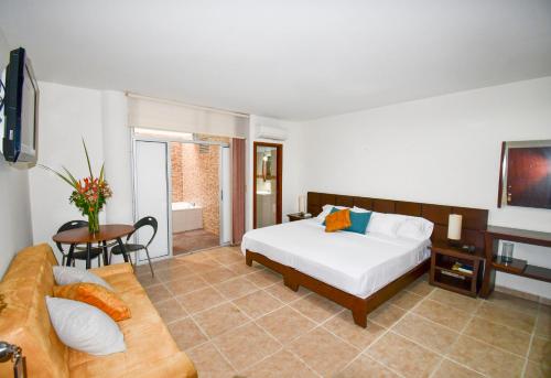 a bedroom with a bed and a couch at Hotel Mónaco Armenia in Armenia