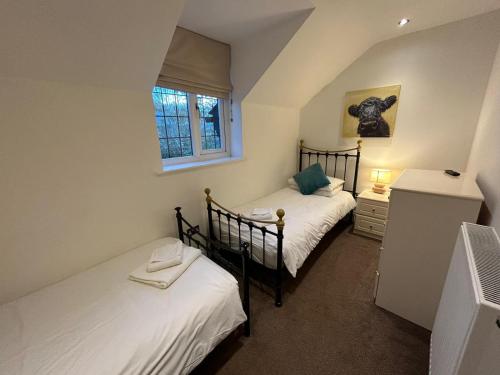 Habitación pequeña con 2 camas individuales y ventana en Castlebar, en Great Singleton