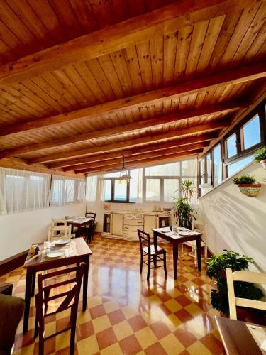 Atenea Luxury Suites - Atenea Collection في أغريغينتو: غرفة معيشة بسقوف خشبية وطاولات وكراسي