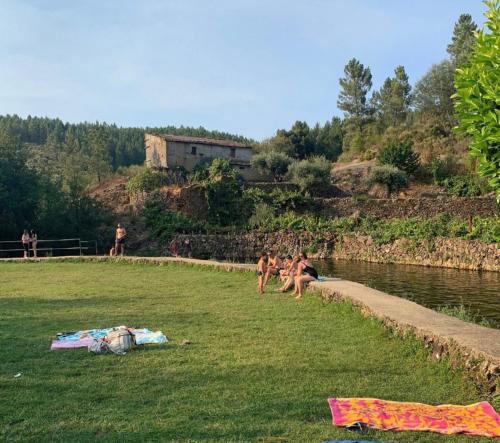a group of children playing in the grass near a river at Casa do Adro in Lavacolhos