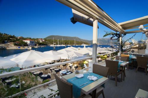 a restaurant with tables and umbrellas on a balcony at FiscardoStudios in Fiskardho