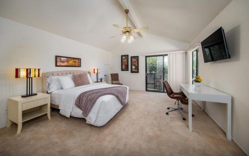 a bedroom with a bed and a desk and a television at Peaceful Private Retreat In The Heart Of Town in Redlands
