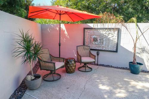 a patio with two chairs and a red umbrella at Peaceful Private Retreat In The Heart Of Town in Redlands