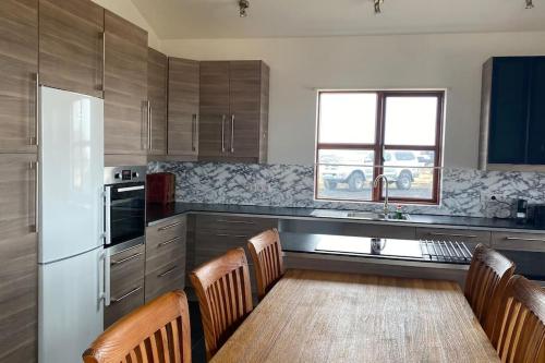 a kitchen with a table and chairs and a refrigerator at Eaglerock Guesthouse and tours in Kirkjubæjarklaustur