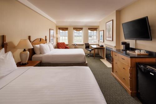 a hotel room with two beds and a flat screen tv at St. Eugene Golf Resort & Casino in Cranbrook