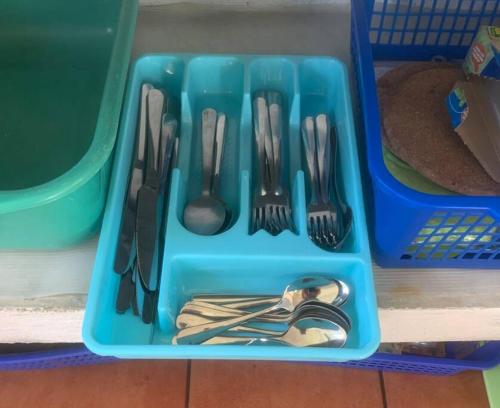 a blue plastic tray with forks and spoons and forks and knives at Monterrico Casablanca in Chiquimulilla