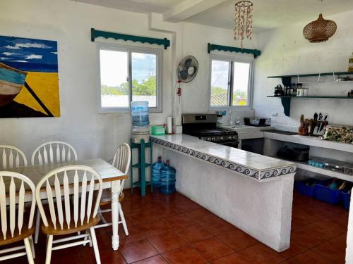 a kitchen with a counter and a table and chairs at Monterrico Casablanca in Chiquimulilla
