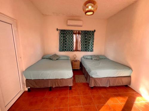 a room with two beds and a window at Monterrico Casablanca in Chiquimulilla