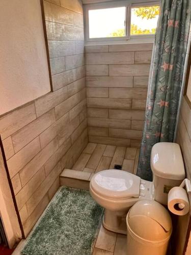 a small bathroom with a toilet and a window at Monterrico Casablanca in Chiquimulilla