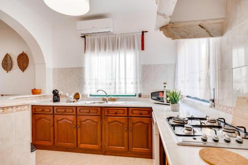 a kitchen with wooden cabinets and a stove top oven at Lugar do Regato - Alojamento Local in Portel