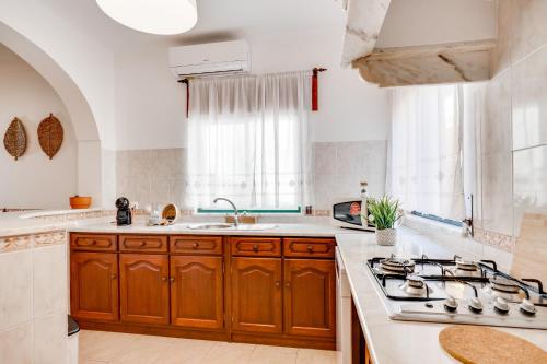 uma cozinha com armários de madeira e um forno com placa de fogão em Lugar do Regato - Alojamento Local em Portel