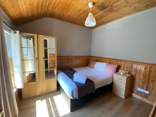 a bedroom with a bed and a wooden ceiling at Cosy City Centre Guest Room Shared Home in Galway