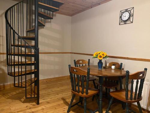 a dining room with a table and a spiral staircase at Cosy City Centre Guest Room Shared Home in Galway