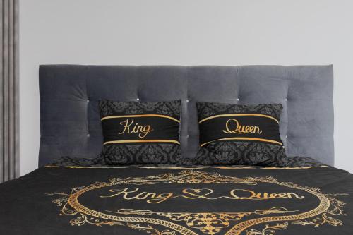 uma cama com uma colcha e almofadas pretas e douradas em Szampan i Truskawka em Toruń
