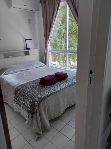 1 dormitorio con 1 cama con 2 almohadas rojas en Rolgar en Mendoza