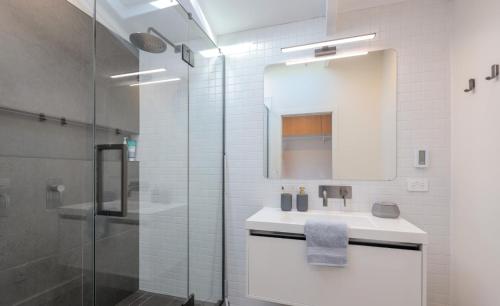 a white bathroom with a sink and a shower at City Apartments in Nelson