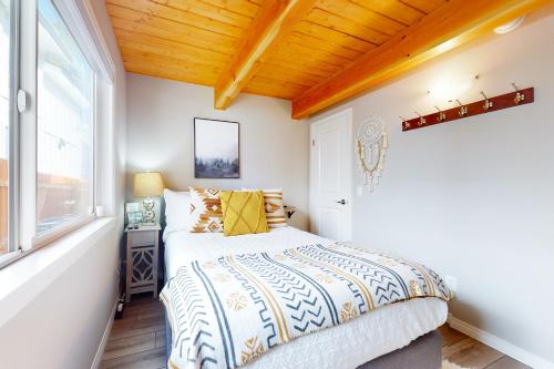 Schlafzimmer mit einem Bett und einem Fenster in der Unterkunft Hemlock Haven in Lake Arrowhead