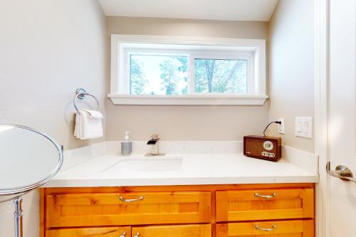 a bathroom with a sink and a window at Hemlock Haven in Lake Arrowhead