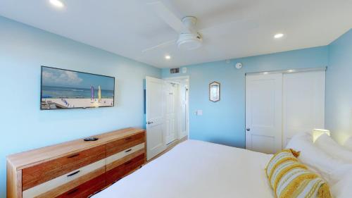 1 dormitorio con 1 cama con pared azul en Soft, Sandy Beaches I Long Views from Premiere Over-sized Balcony!, en Marco Island