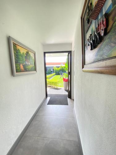 a hallway of a house with paintings on the walls at Berlor Airport Inn in Alajuela City