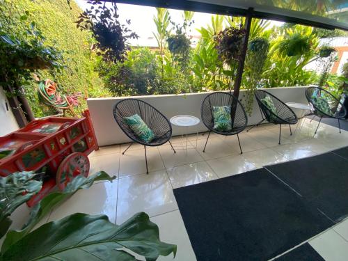a patio with four chairs and an umbrella at Berlor Airport Inn in Alajuela City