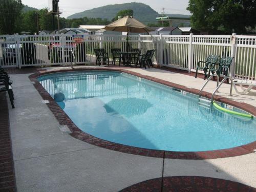 una piscina in un cortile con tavolo e sedie di Mountain inn & suites - Dunlap TN a Dunlap