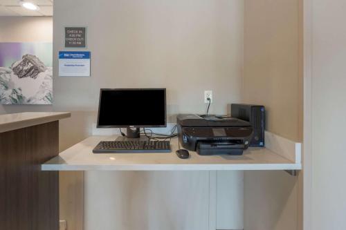 a desk with a computer monitor and a printer at Best Western Plus Chena River Lodge in Fairbanks