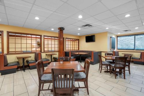 een restaurant met tafels en stoelen en een tv bij Best Western Louisville East Inn & Suites in Louisville