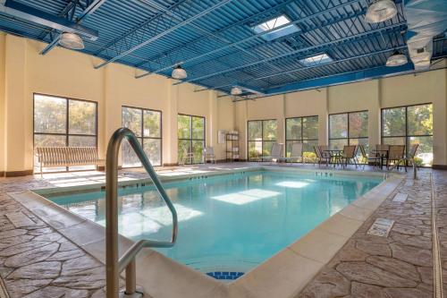 a large swimming pool with blue ceilings and windows at Best Western Louisville East Inn & Suites in Louisville