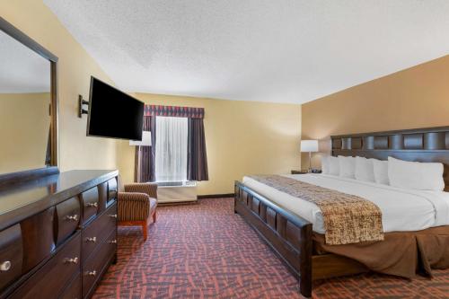 a hotel room with a bed and a flat screen tv at Best Western Louisville East Inn & Suites in Louisville