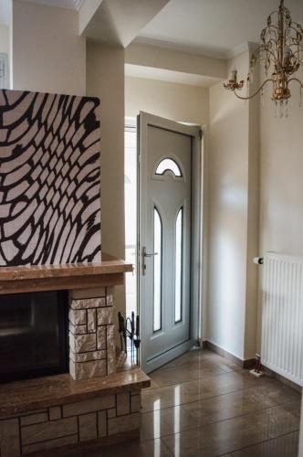 a living room with a fireplace and a door at g.home in Tríkala