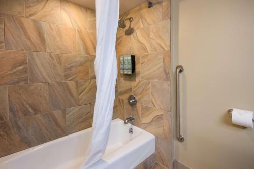 a bathroom with a shower with a tub and a toilet at Best Western Weston Inn in West Yellowstone
