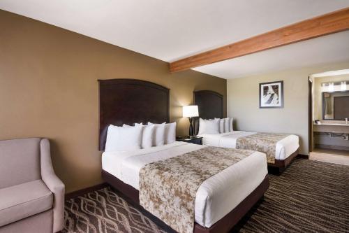 a hotel room with two beds and a chair at Best Western Weston Inn in West Yellowstone