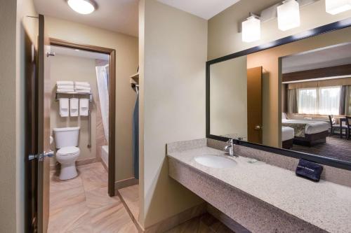 a bathroom with a sink and a toilet and a mirror at Best Western Weston Inn in West Yellowstone
