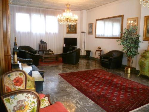 a living room filled with furniture and a chandelier at Hotel Minerva in Pordenone