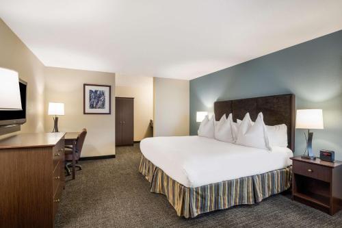 a hotel room with a large white bed and a desk at Best Western Windsor Inn in Ashland