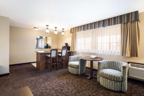 a hotel room with a bar and a table and chairs at Best Western Windsor Inn in Ashland