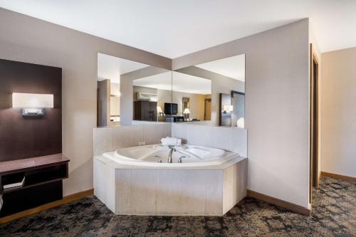 a large bathroom with a tub and a large mirror at Best Western Windsor Inn in Ashland