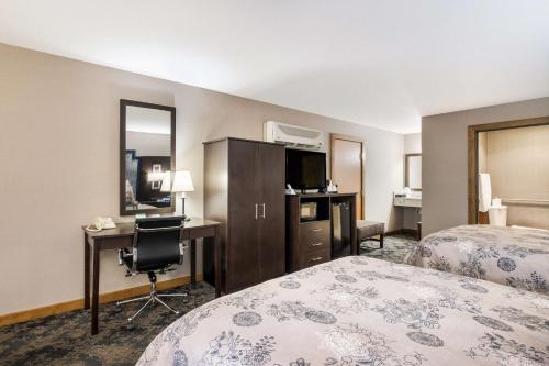 a hotel room with two beds and a desk at Best Western Windsor Inn in Ashland