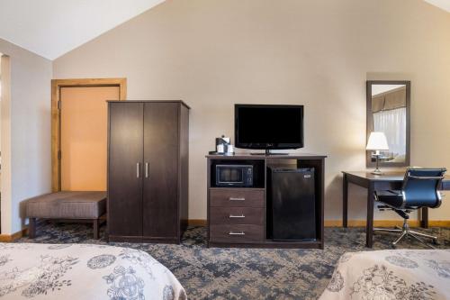 a hotel room with a bed and a television and a desk at Best Western Windsor Inn in Ashland
