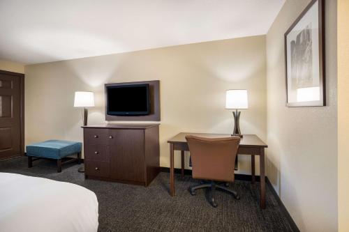 a hotel room with a desk with a television and a bed at Best Western Windsor Inn in Ashland