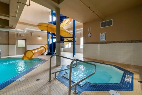a swimming pool with a slide in a building at Best Western Cold Lake Inn in Cold Lake