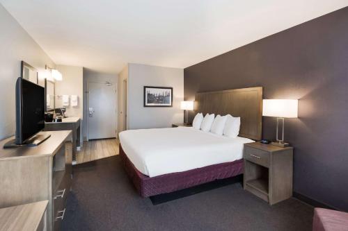 a hotel room with a bed and a flat screen tv at Best Western McMinnville Inn in McMinnville